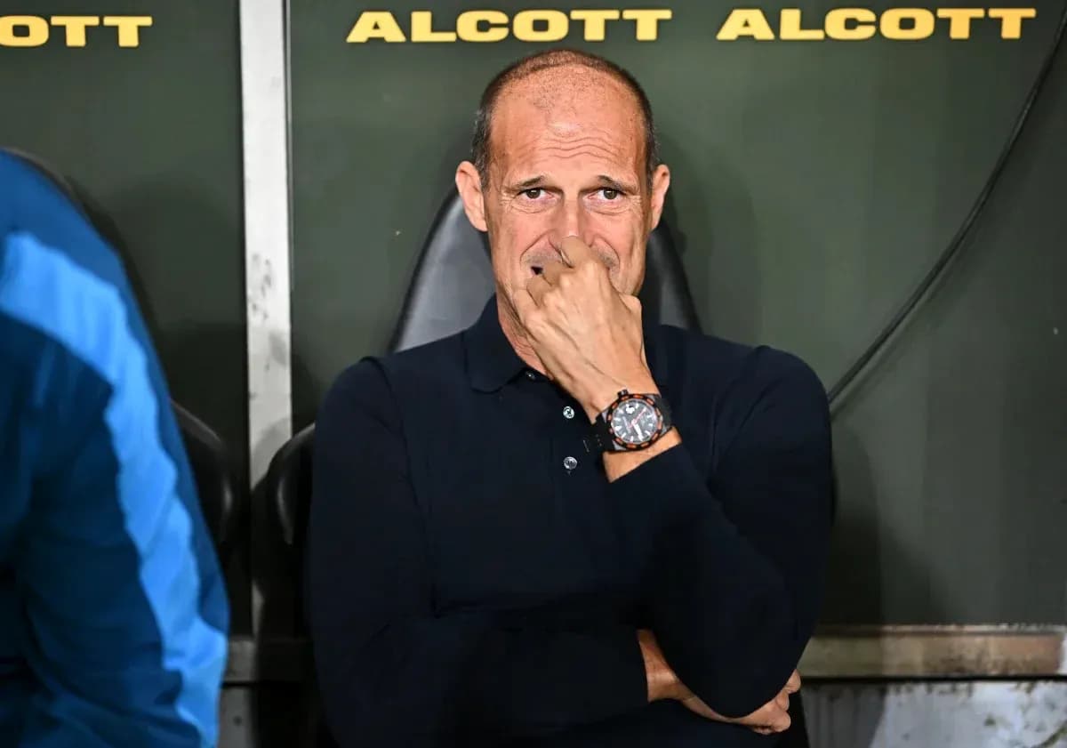 Coach seated on bench during match, deep in thought