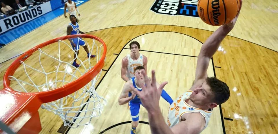 Player dunking while defenders watch during game