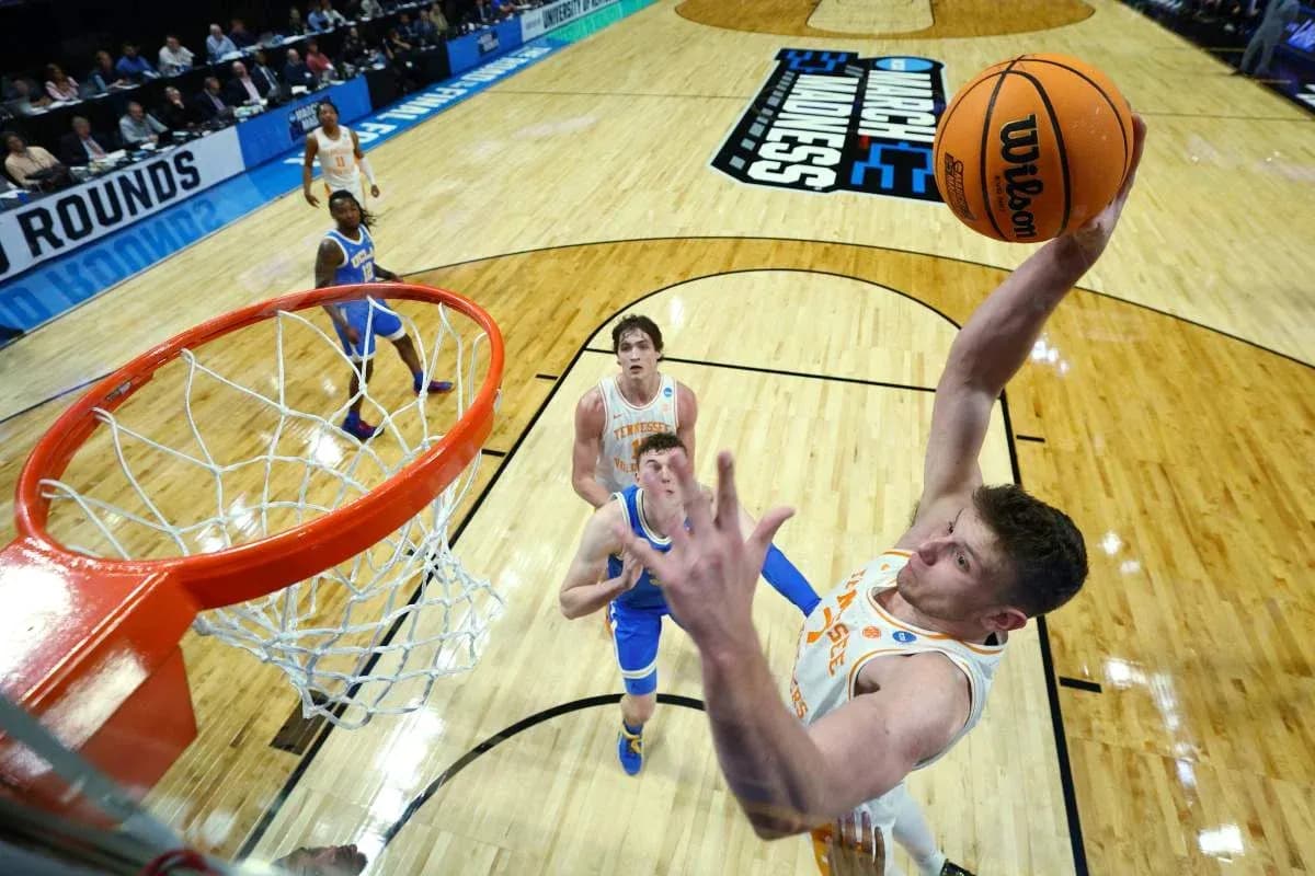 Player dunking while defenders watch during game