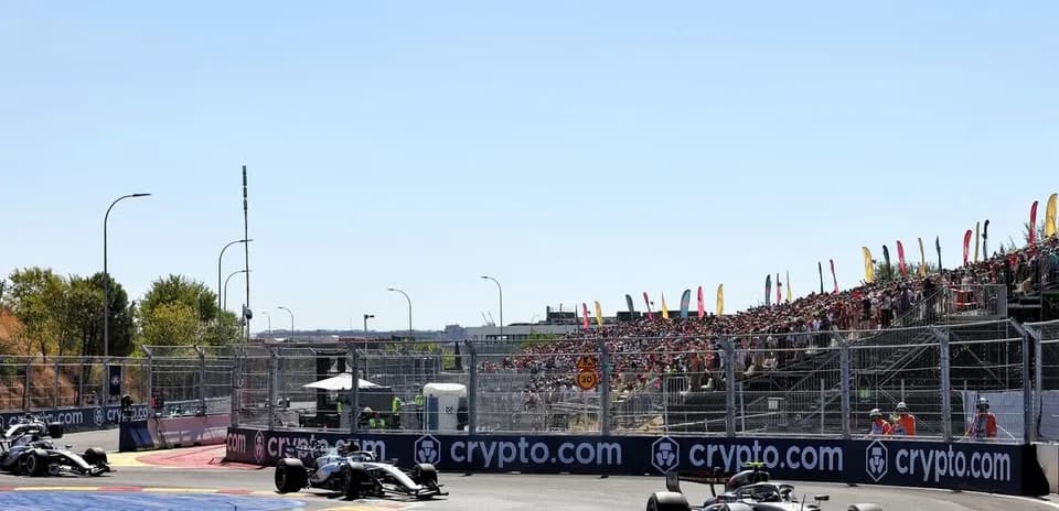 Formula 1 cars racing on track with spectators