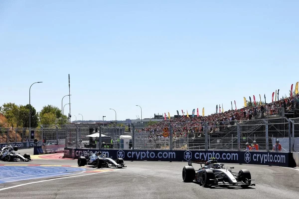 Formula 1 cars racing on track with spectators