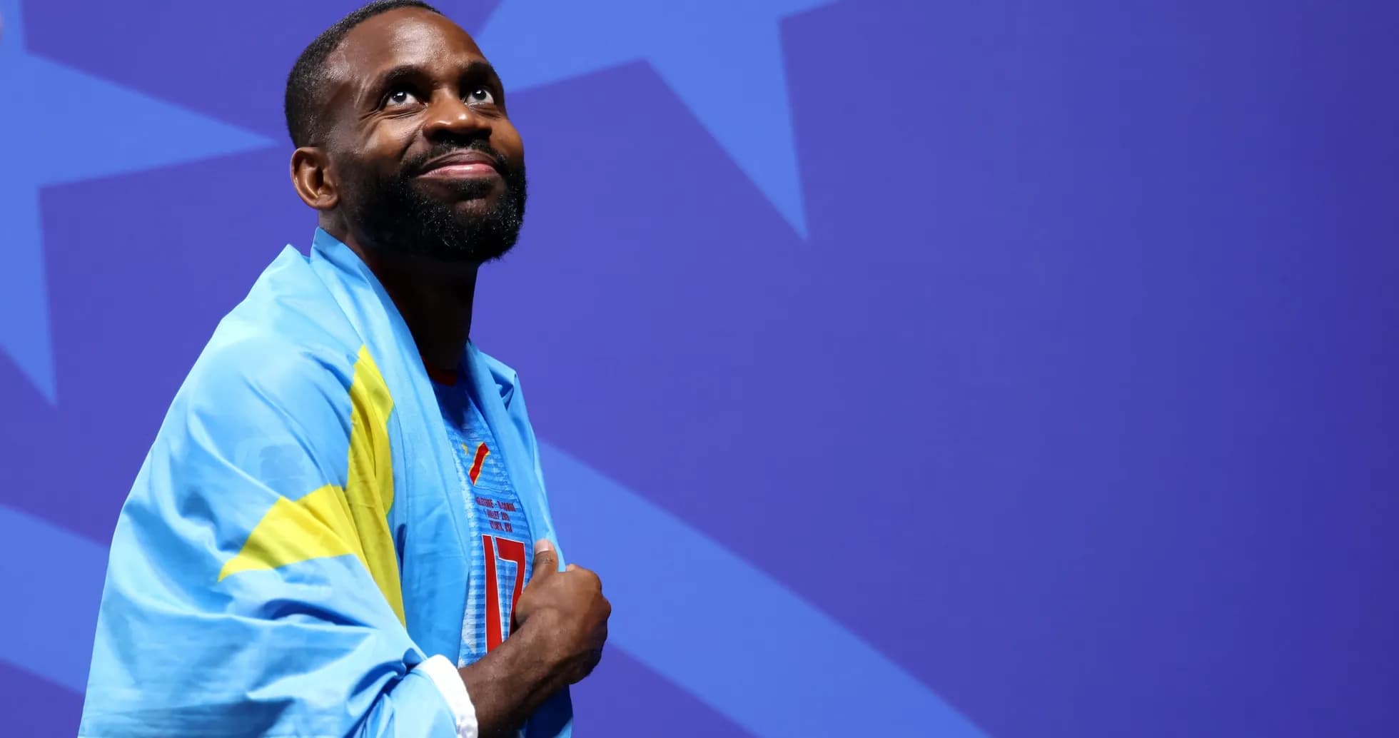 Athlete wearing a blue flag, looking upward Athlete wearing a blue flag, looking upward