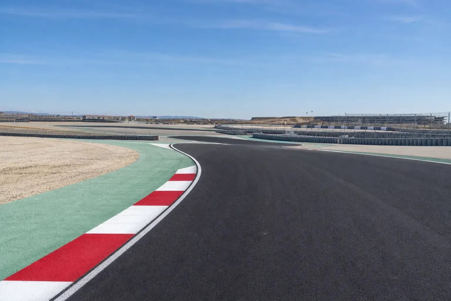 Curved racetrack with colored curbing and stands Curved racetrack with colored curbing and stands