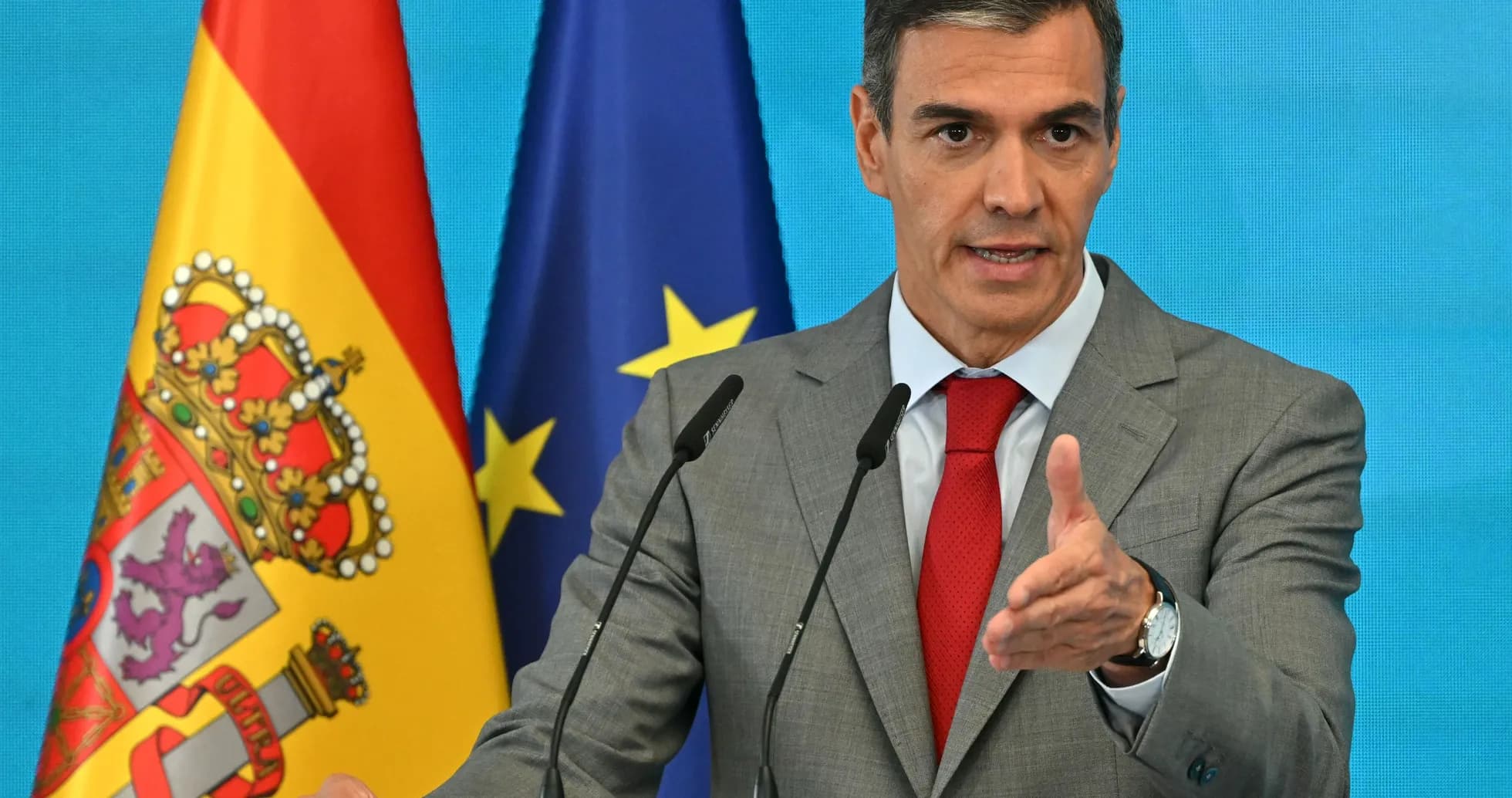 Politician speaking at podium with flags in background Politician speaking at podium with flags in background