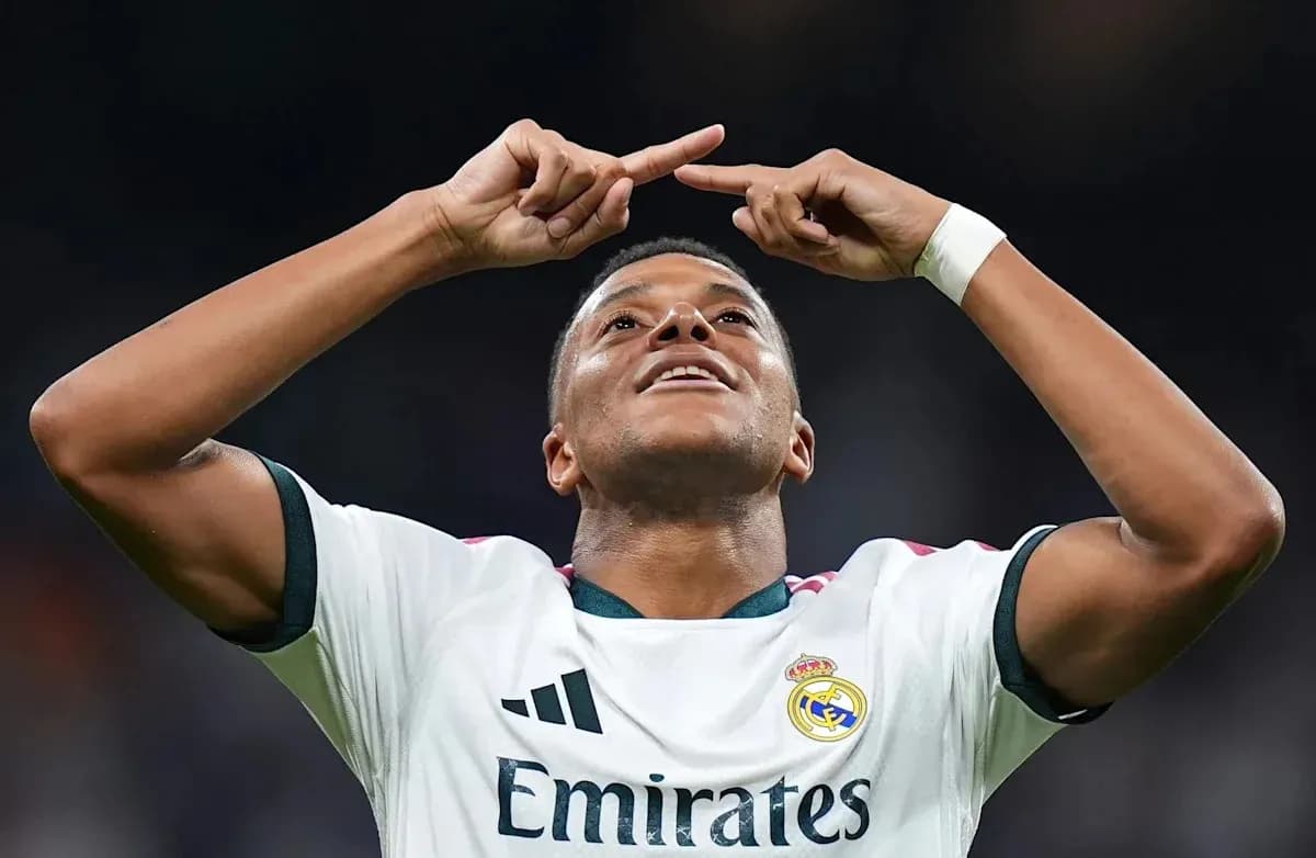 Player celebrating goal with arms raised in stadium Player celebrating goal with arms raised in stadium