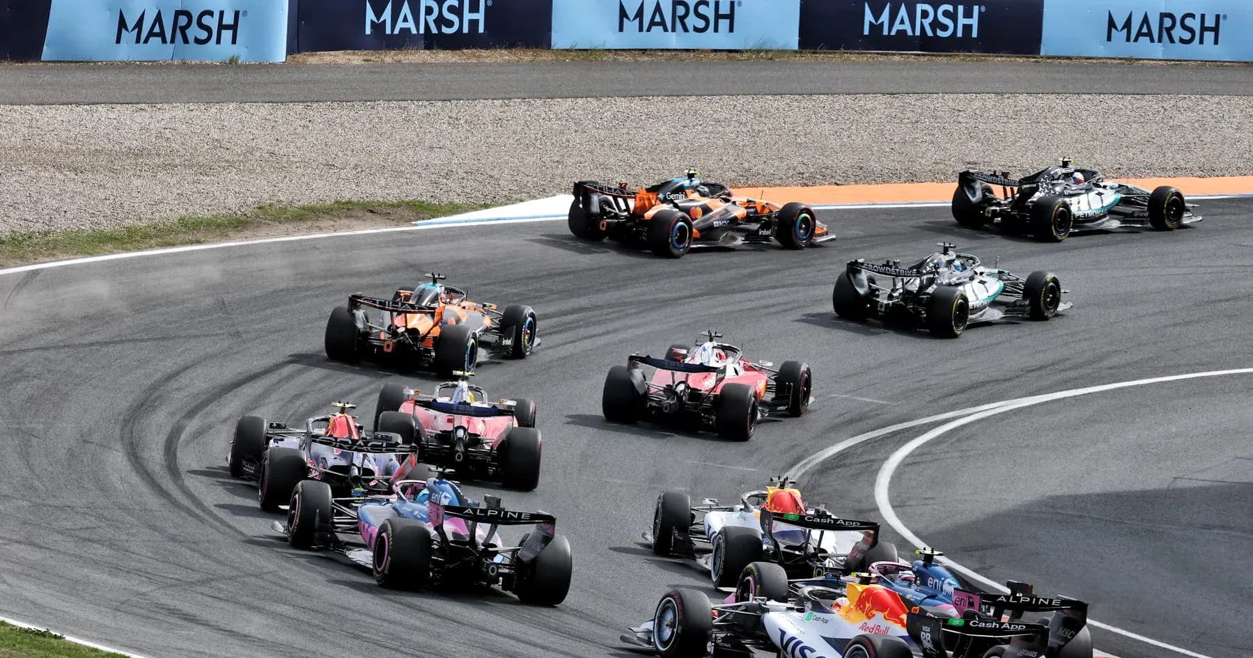 Formula 1 cars racing through a tight corner Formula 1 cars racing through a tight corner