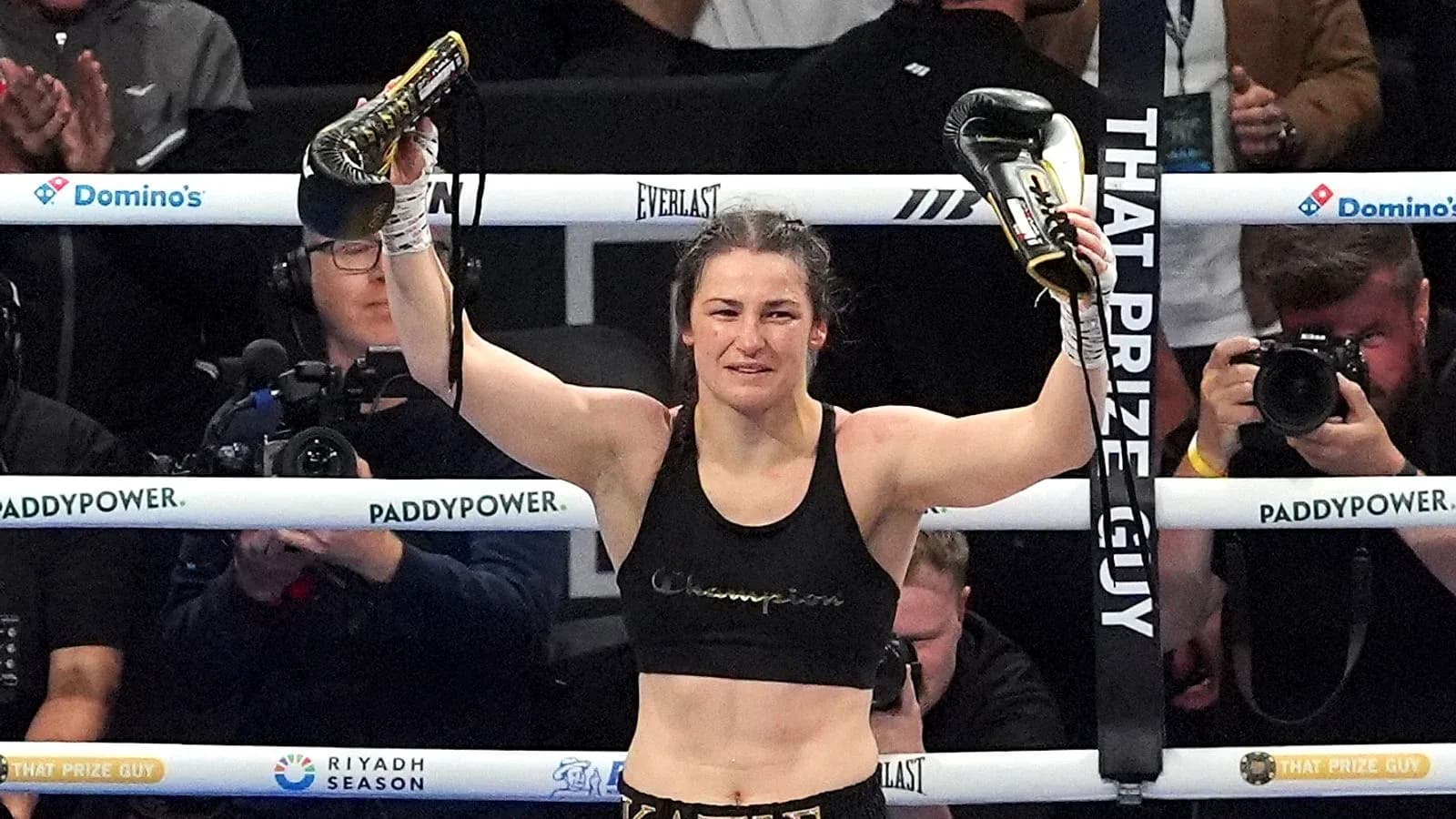 Female boxer celebrating victory with gloves raised Female boxer celebrating victory with gloves raised