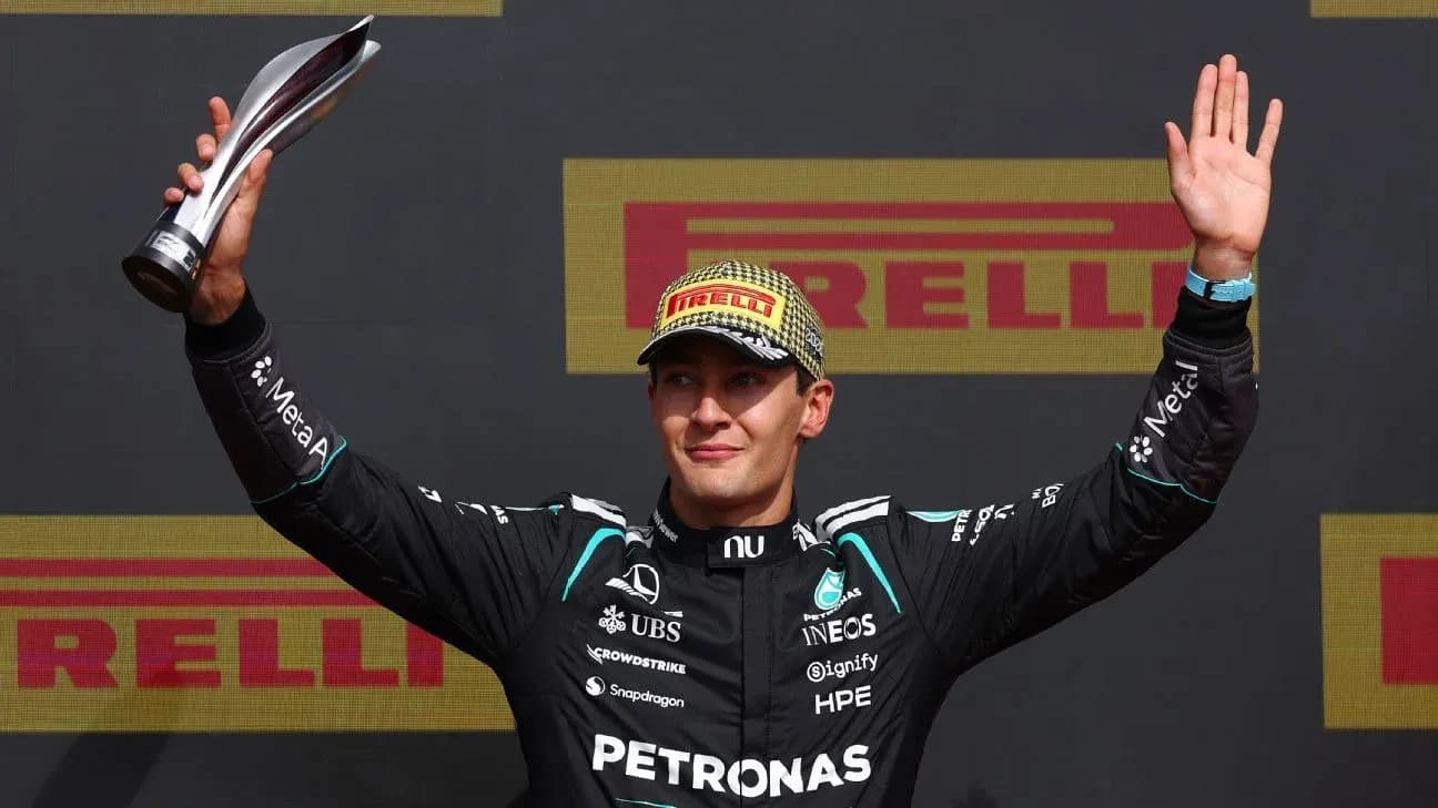 Driver celebrating with trophy on podium after race Driver celebrating with trophy on podium after race