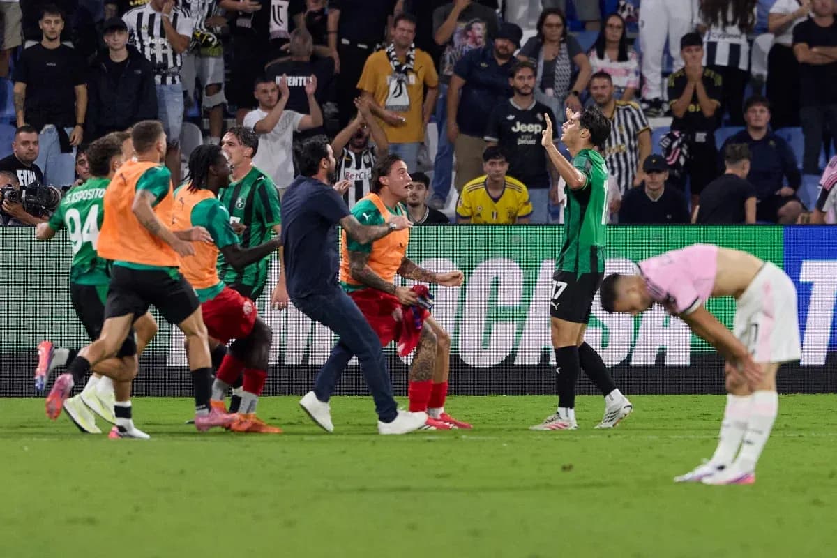 Players celebrating a goal with fans in the background Players celebrating a goal with fans in the background