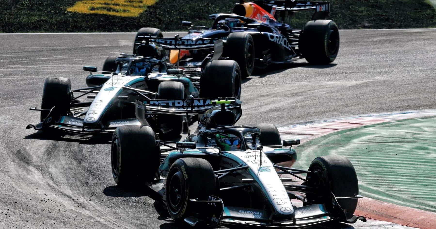 Three Formula 1 cars racing on track Three Formula 1 cars racing on track