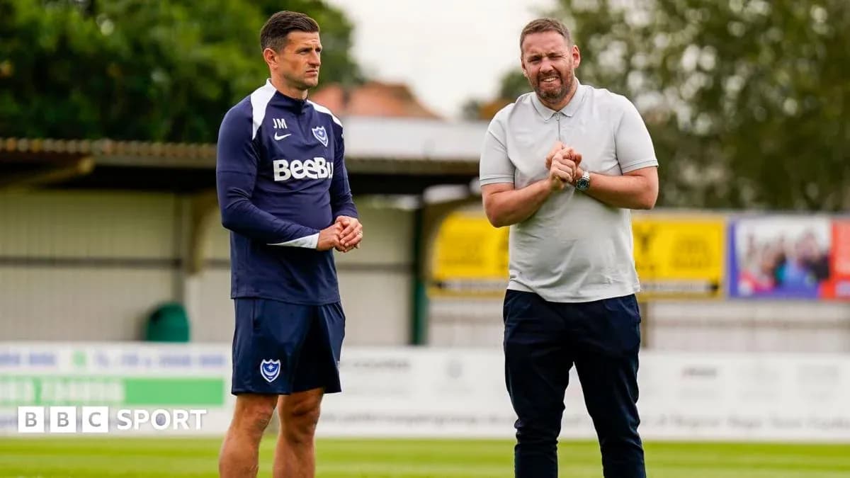 Two coaches discussing on training pitch Two coaches discussing on training pitch