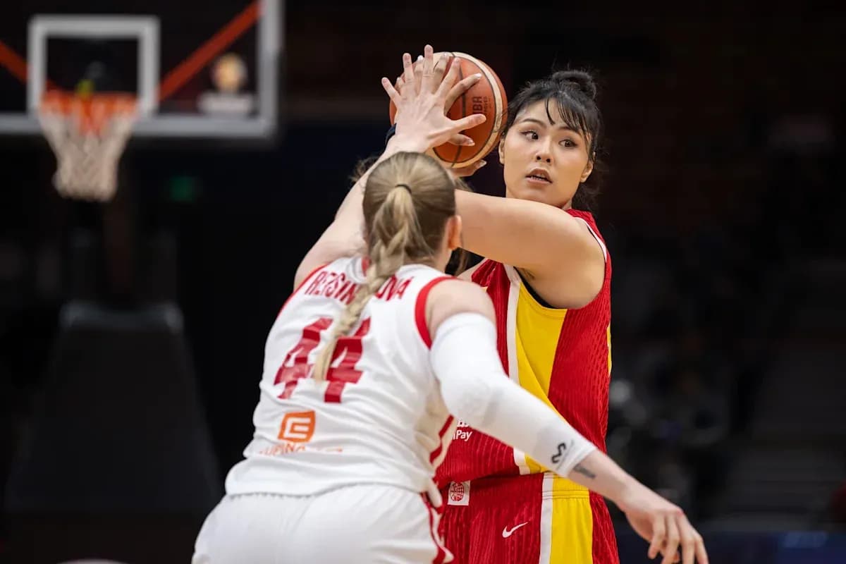 Player passing ball while being closely guarded Player passing ball while being closely guarded