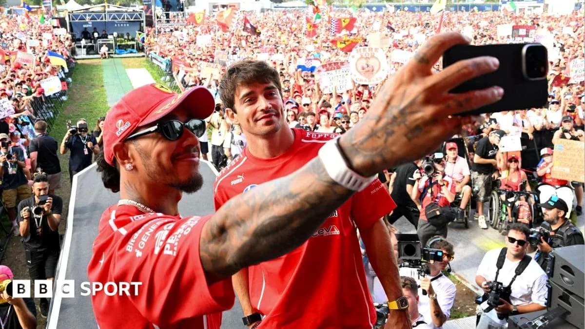 Two drivers taking a selfie with fans behind Two drivers taking a selfie with fans behind