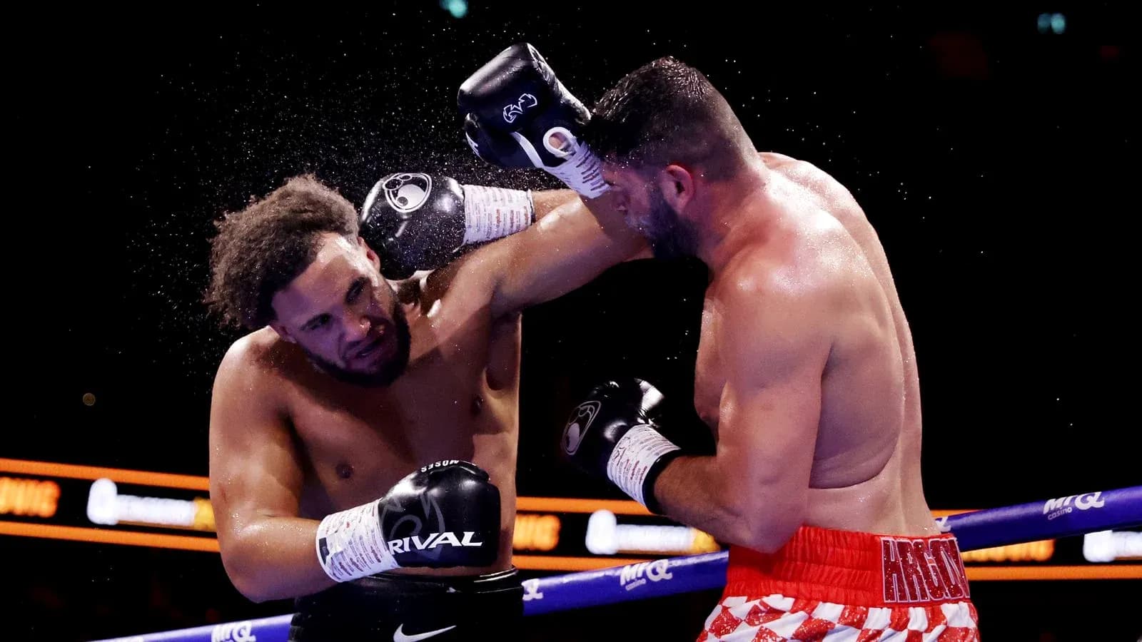 Two boxers exchanging punches in the ring Two boxers exchanging punches in the ring