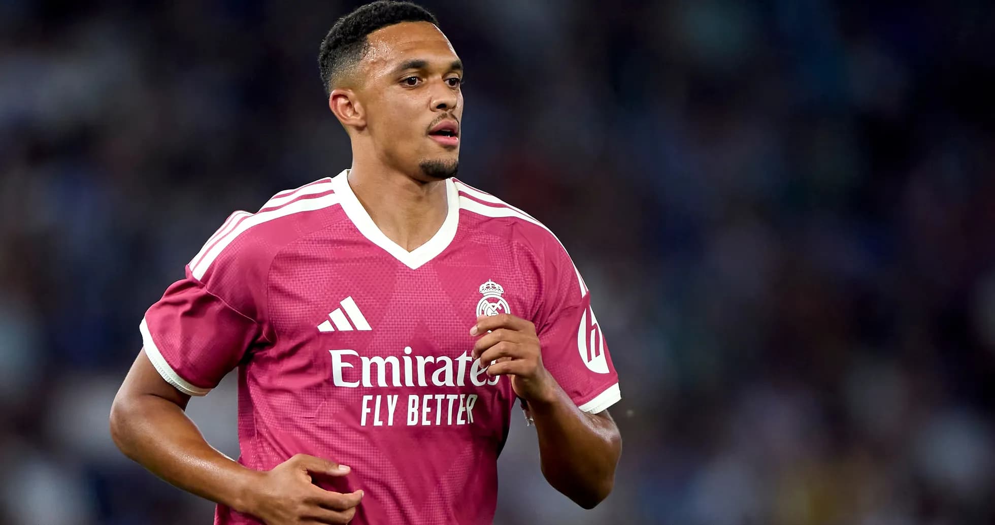 Player in pink Real Madrid jersey running on field Player in pink Real Madrid jersey running on field