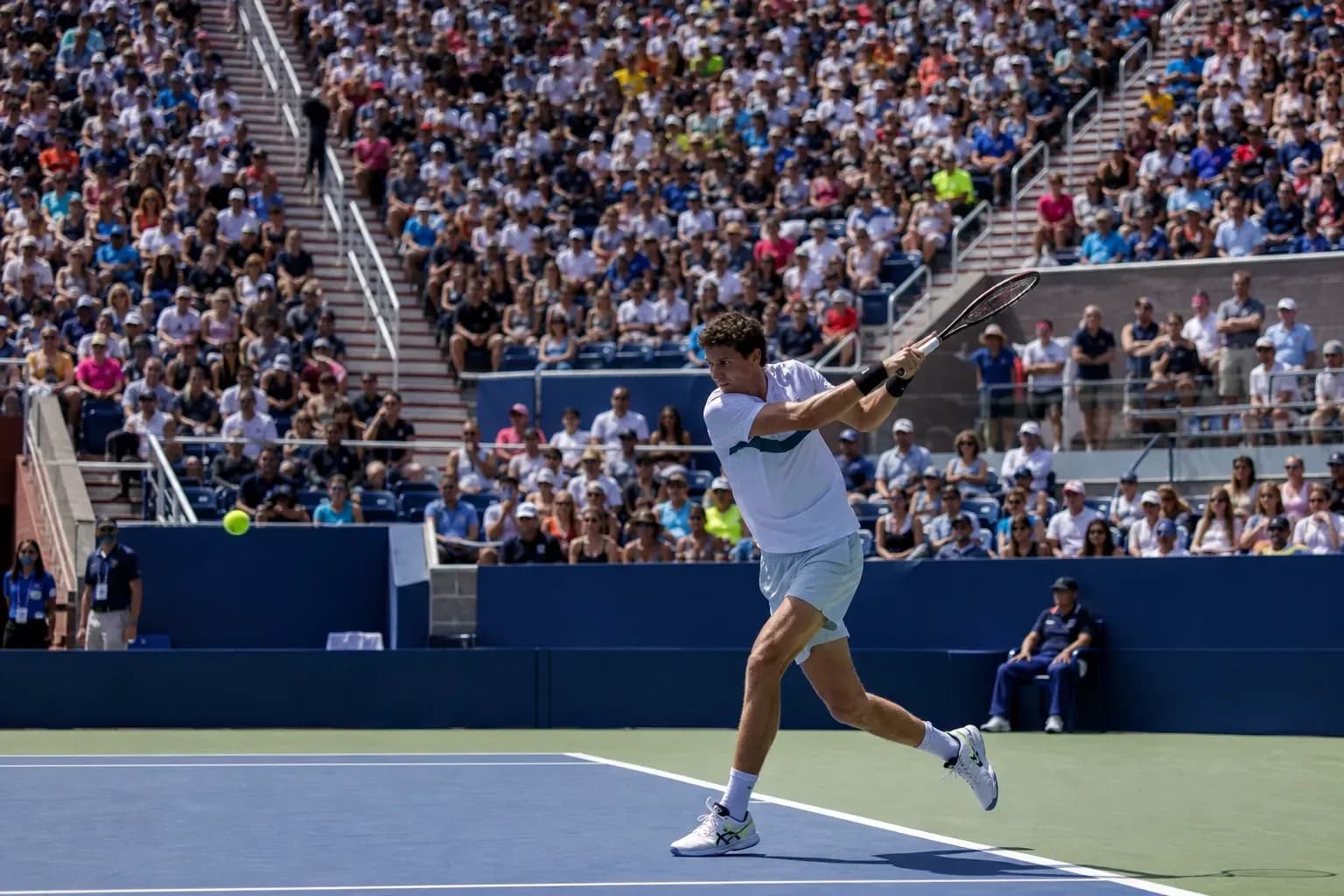 Player hitting a backhand during a tennis match Player hitting a backhand during a tennis match