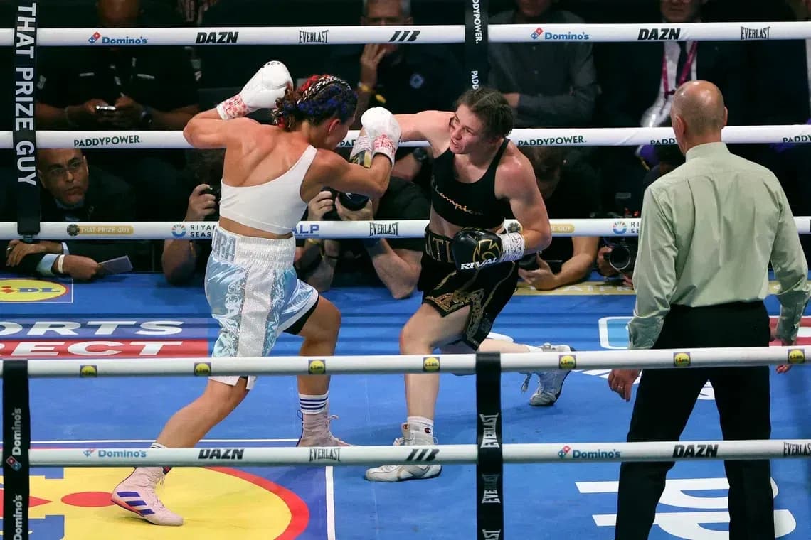 Two female boxers exchanging punches in the ring Two female boxers exchanging punches in the ring