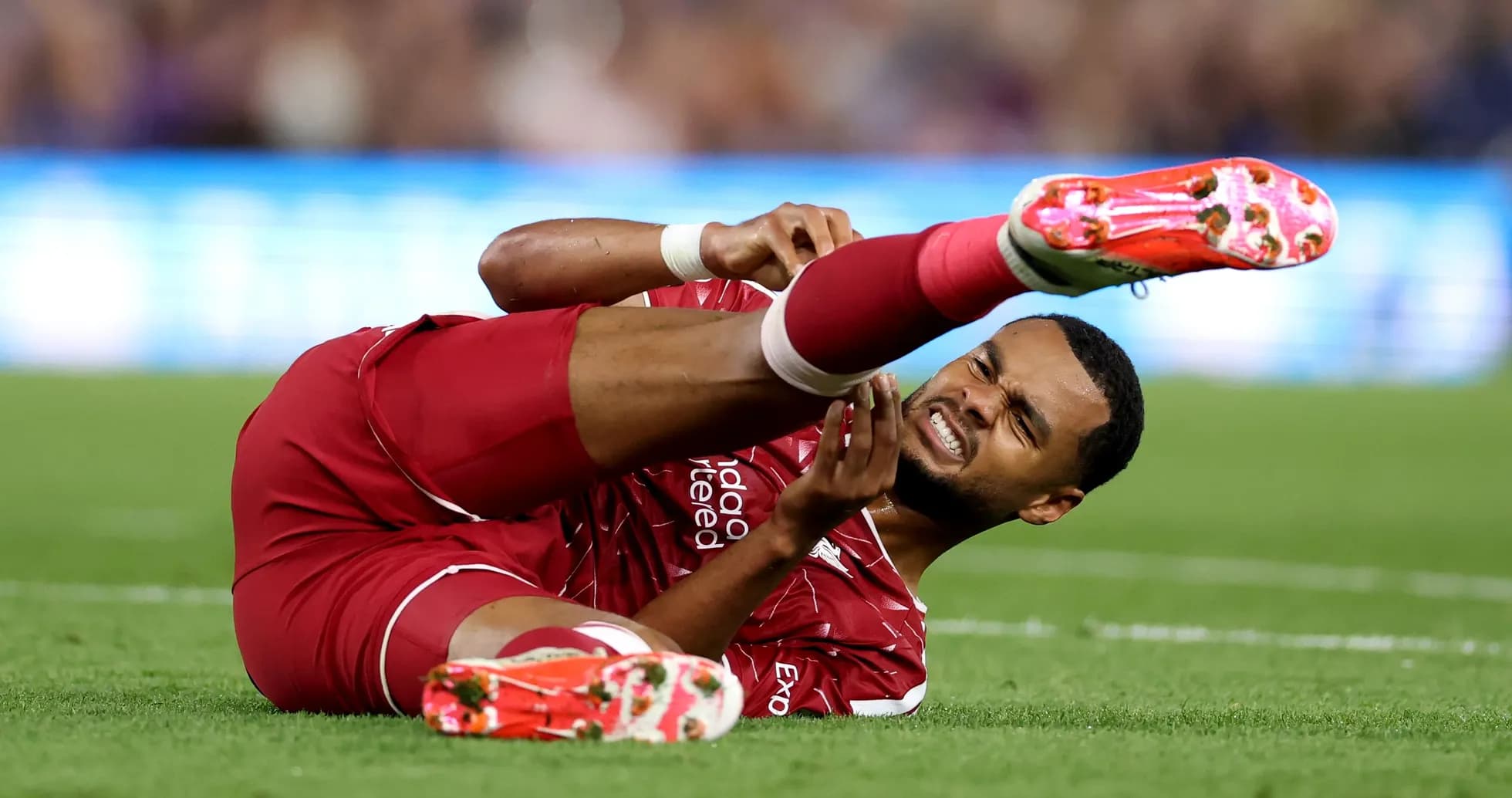 Player lying on ground clutching injured leg Player lying on ground clutching injured leg
